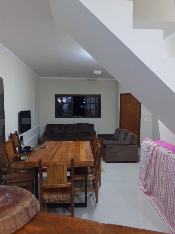 a living room with a wooden table and a couch at Ecovila in São Sebastião