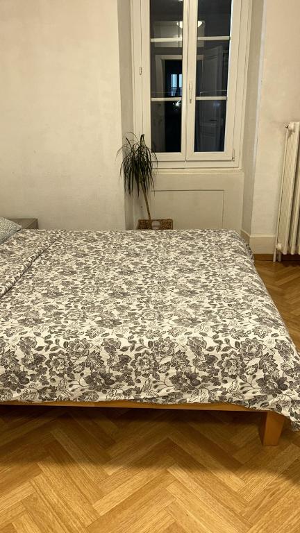 a bed with a black and white comforter on it at Piso Chauderon in Lausanne