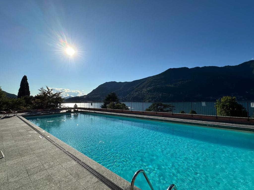 a large swimming pool with a view of the water at LA CALETTA SUITE APARTMENT- Panoramic Shared Pool, Secured Parking, Water Activities in Blevio