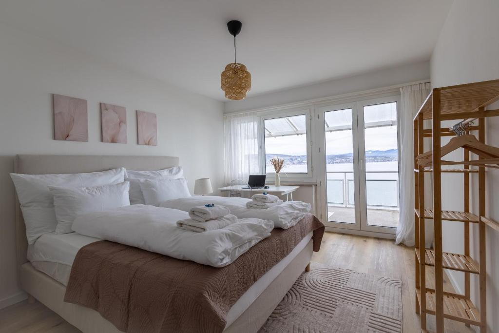 a bedroom with a bed with towels on it at Horizon 62 I Zürich Lakeside Apartment I Modern I Free Parking I Self-Check-In in Richterswil