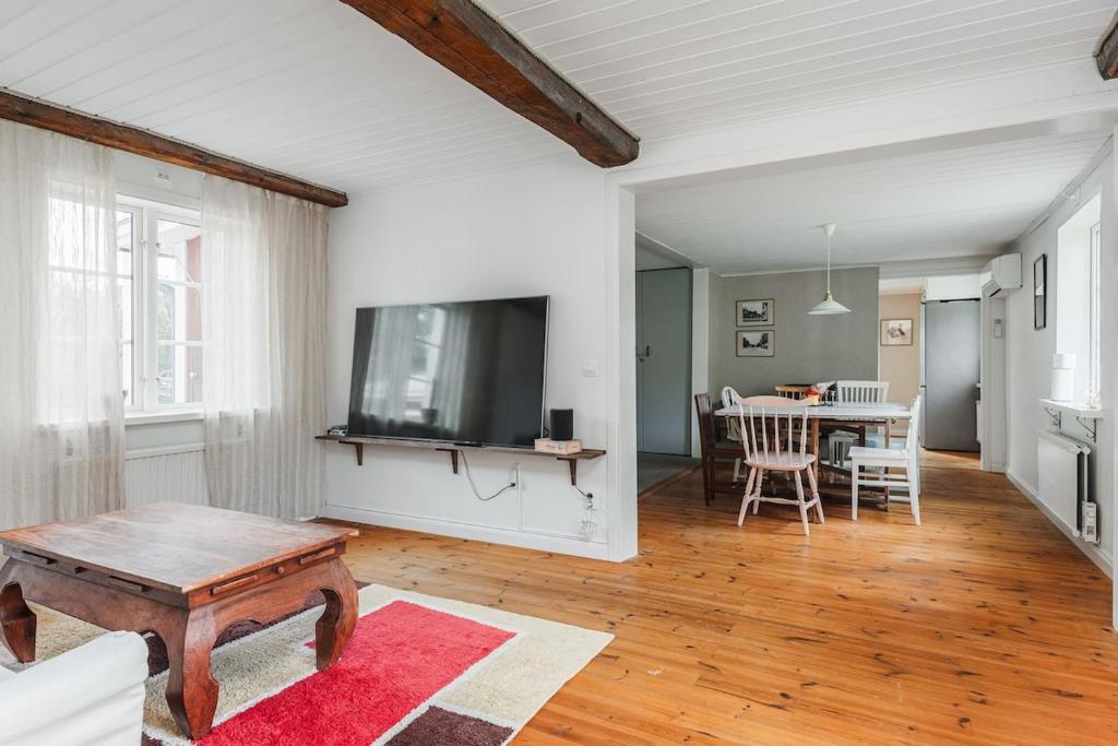 a living room with a tv and a table at Rustic Nordic Getaway by the Sea in Axmar