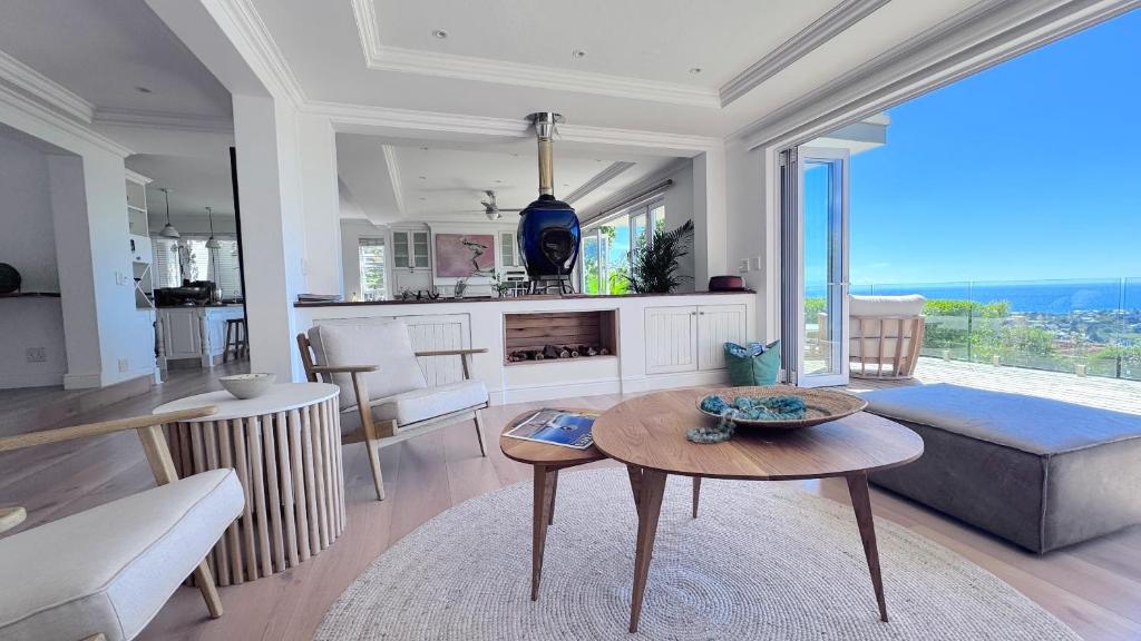 a living room with a table and a kitchen at Plett Azure Guesthouse in Plettenberg Bay