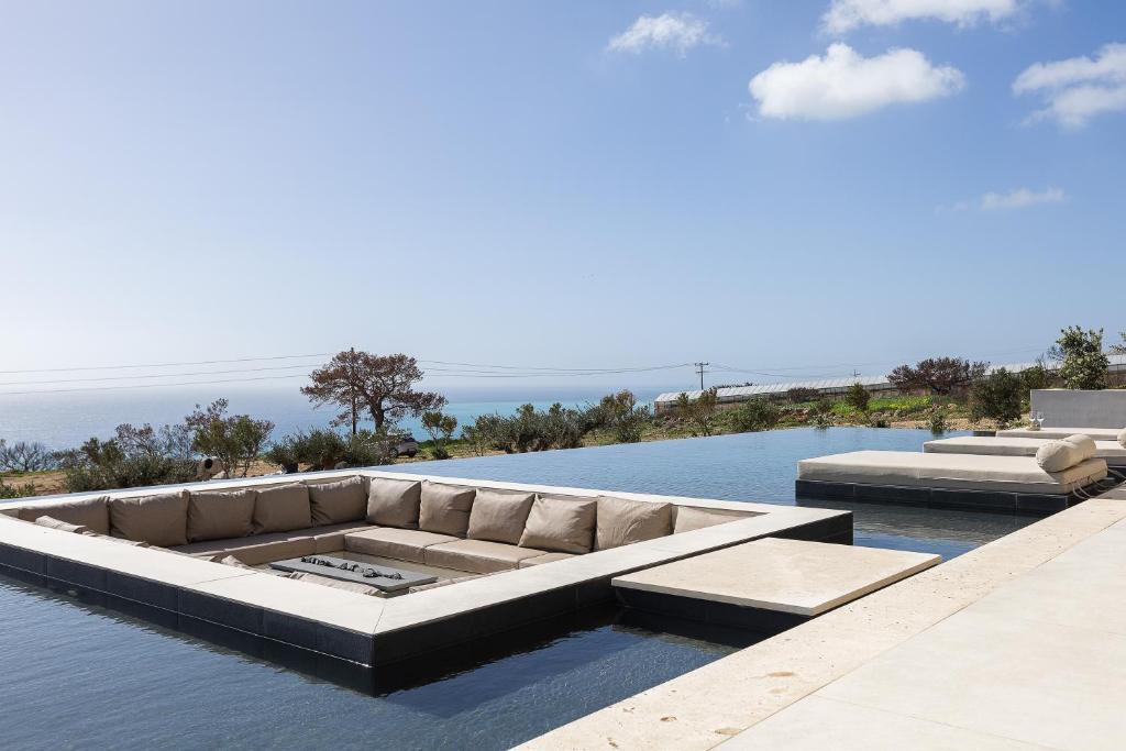 eine Couch, die auf einem Gewässer steht in der Unterkunft Seanatra Luxury Villas in Ferma