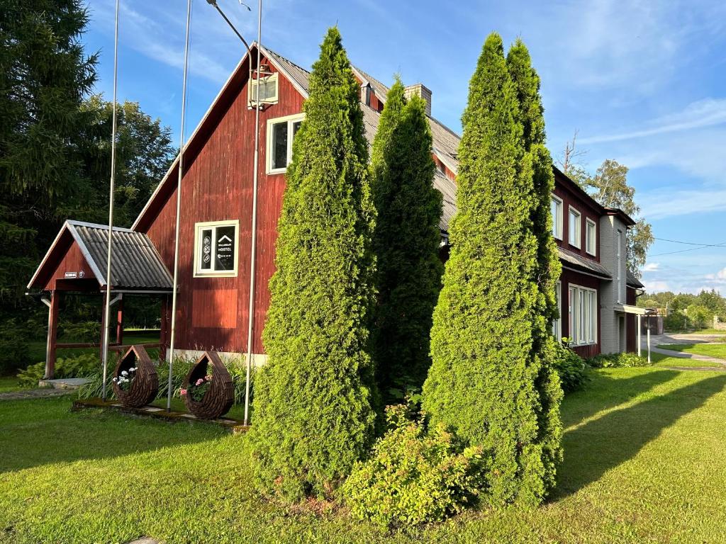 a red house with trees in front of it at Wallamaja Hostel in Järvakandi