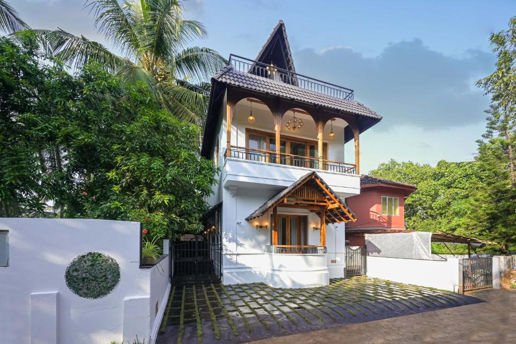 a house with a balcony on top of it at Anjuna Casa Nova in Jāmb