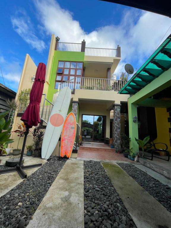 a house with two surfboards in front of it at B2-B Guesthouse in Guiuan