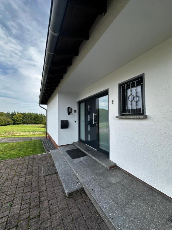 a white building with a door and a window at Mia's Landzeit in Nettersheim