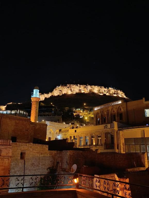 a view of a city at night with a lighthouse at Babussor konağı hotel in Eskiömerler