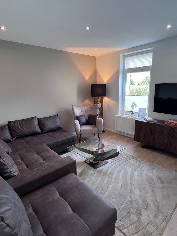 a living room with a couch and a television at Güden Pearl Bhaven Deck 6 ,Exklusive große Wohnung,Hochwertige Ausstattung,Privatparkplatz & Carport,Großer Garten mit Gartenhaus,Langzeitaufenthalt in Bremerhaven