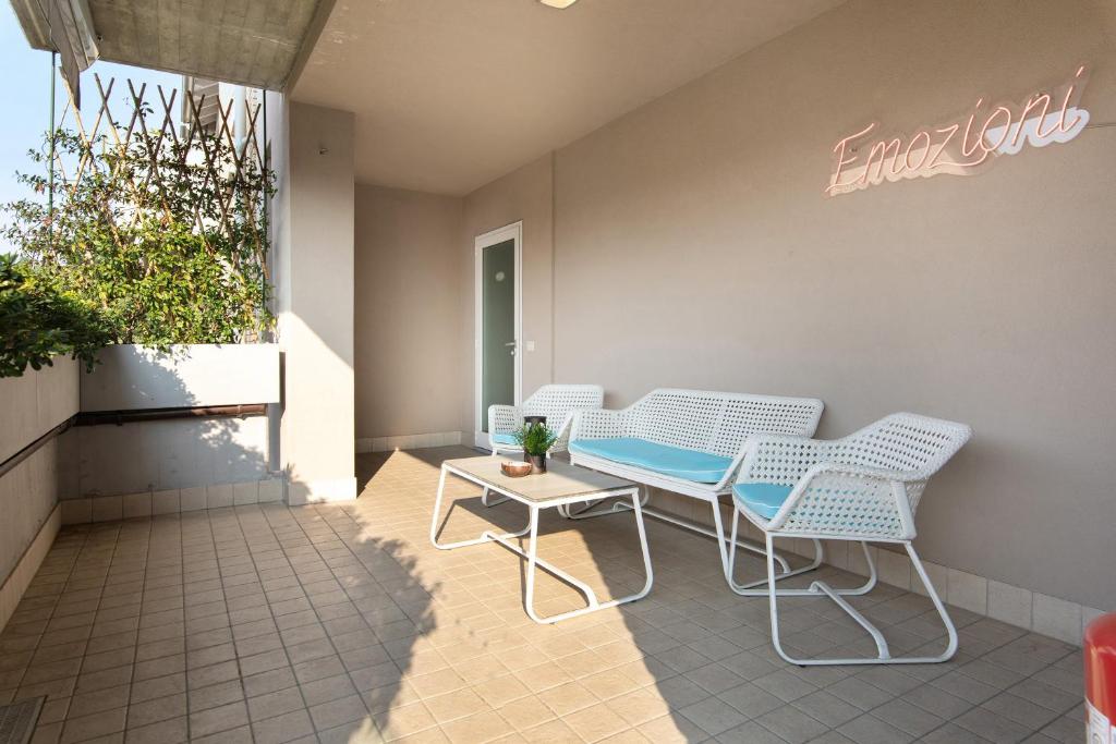 a patio with two chairs and a table and a sign at Maison Emozioni Terrace in Limbiate