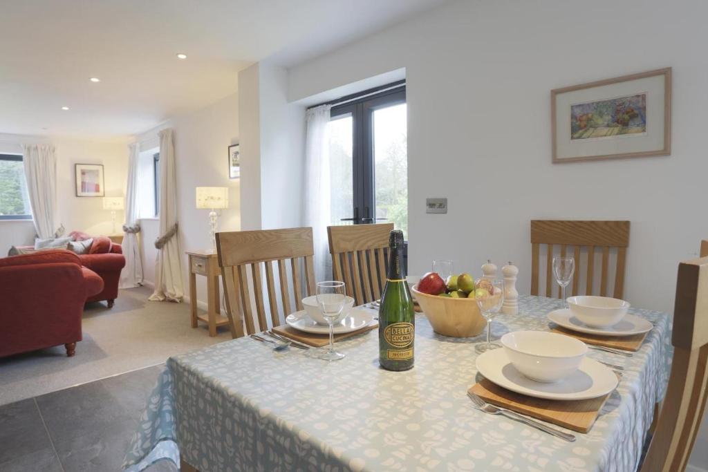 a dining room with a table with a bottle of wine at 2 Bed in Leiston oc-cqa in Theberton