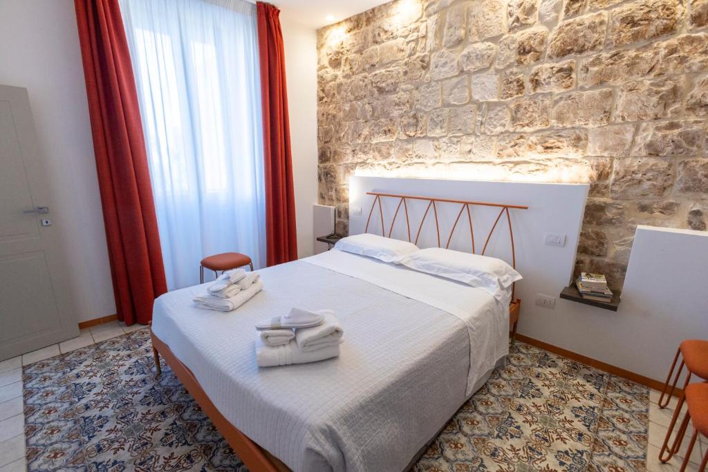 a bedroom with a bed and a stone wall at La Dimora dei WaLori in Bisceglie