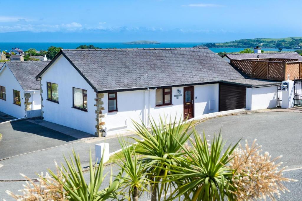 a white house with the ocean in the background at 3 Bed in Abersoch oc-kook72 in Abersoch