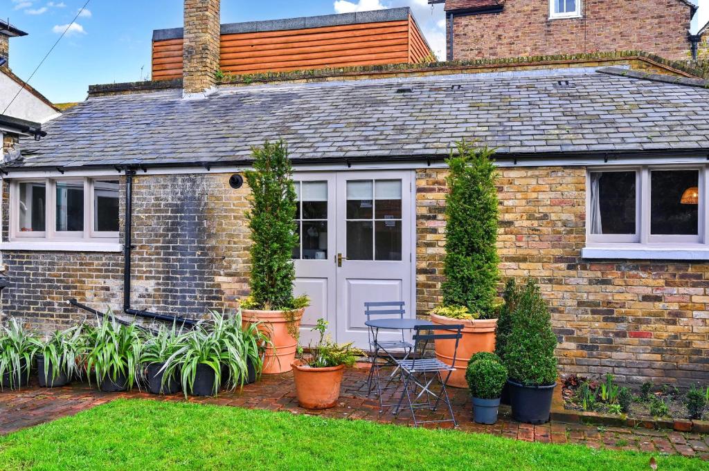 a brick house with a table and chairs in a yard at Finest Retreats - St Germains Annexe in Sandwich