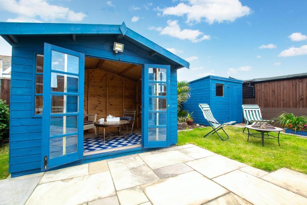 a blue shed with a patio in a yard at 2 Bed in Walcott oc-2209 in Walcott