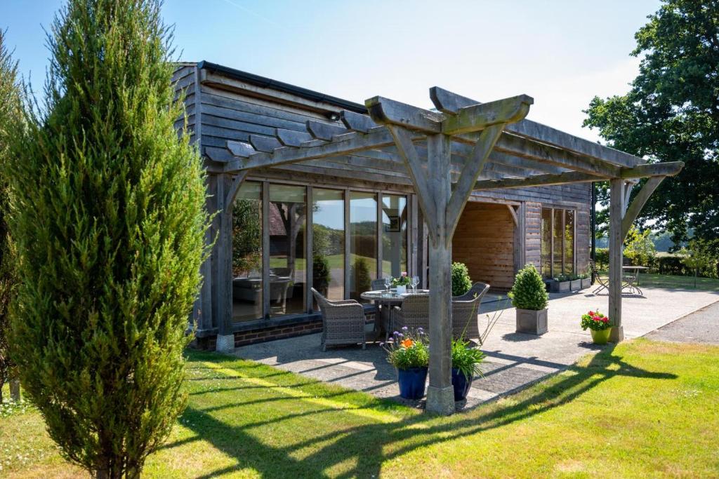 a wooden pergola with a table in a garden at 1 Bed in Beckley oc-rh1151 in Beckley