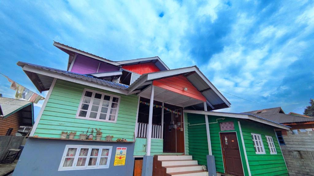 a green and colorful house with a sky at Accomoon Valleyside homes in Mechuka