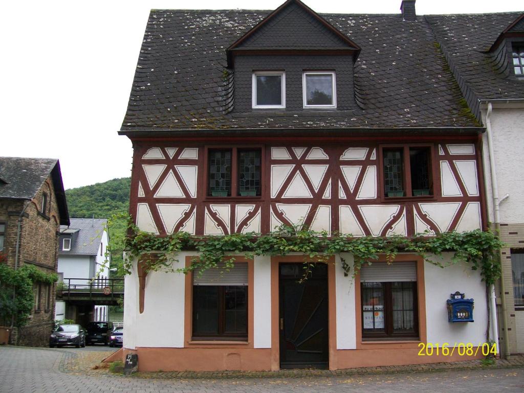 ein schwarzweißes Gebäude mit schwarzem Dach in der Unterkunft Wichtelhaus in Treis-Karden