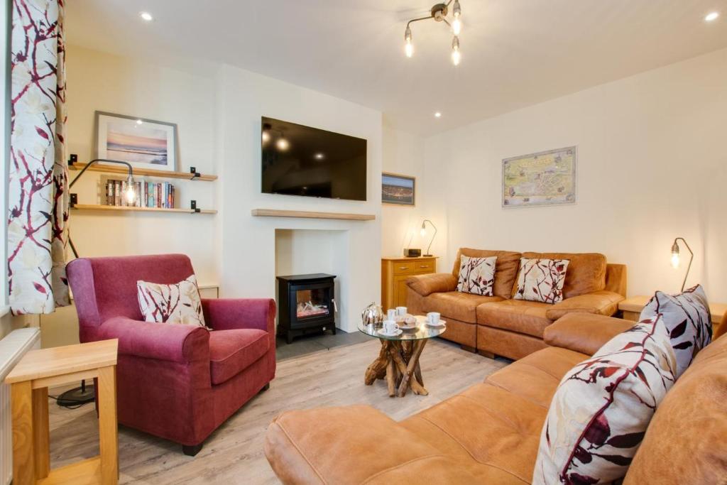 a living room with two couches and a fireplace at 3 Bed in Sheringham oc-2170 in Sheringham