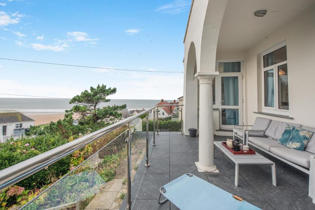 a balcony with a couch and a view of the ocean at 3 Bed in Woolacombe oc-n1711 in Woolacombe