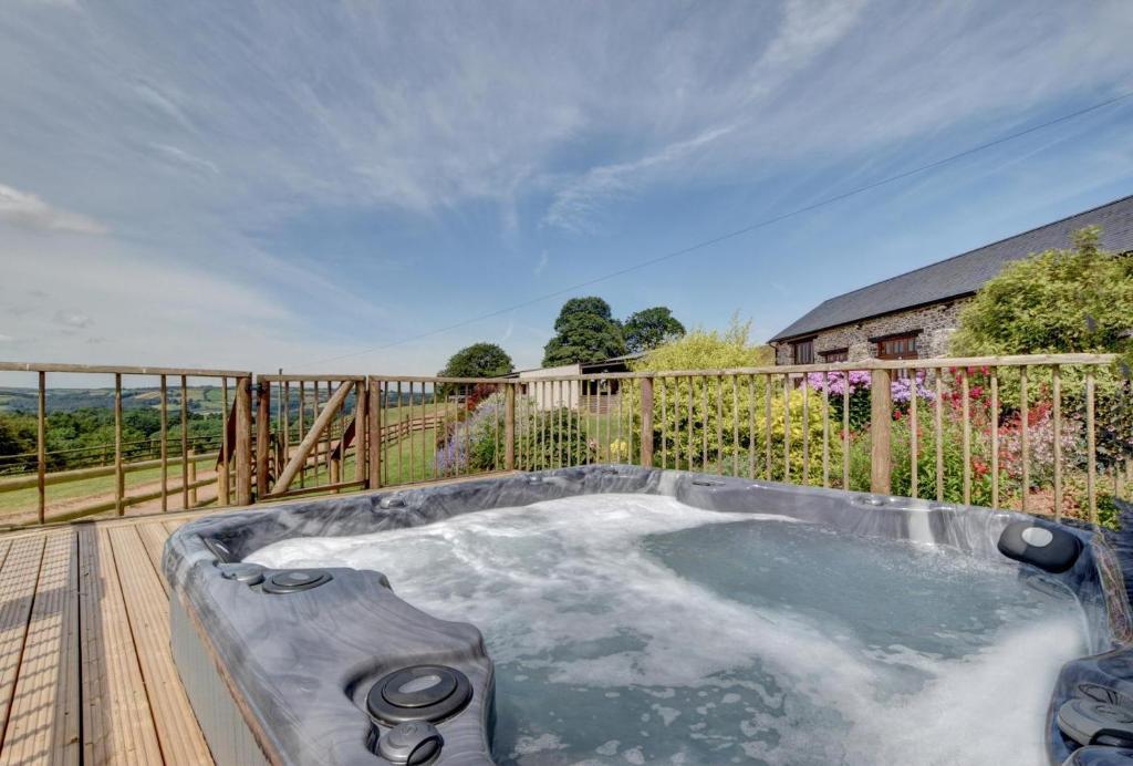 a hot tub on the deck of a house at 1 Bed in Tiverton oc-gear in Bampton