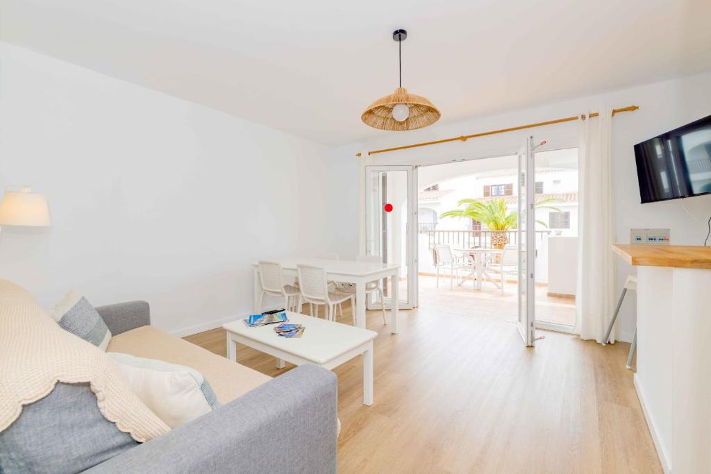 a living room with a couch and a table at Siesta Mar Apartamentos in Cala en Porter