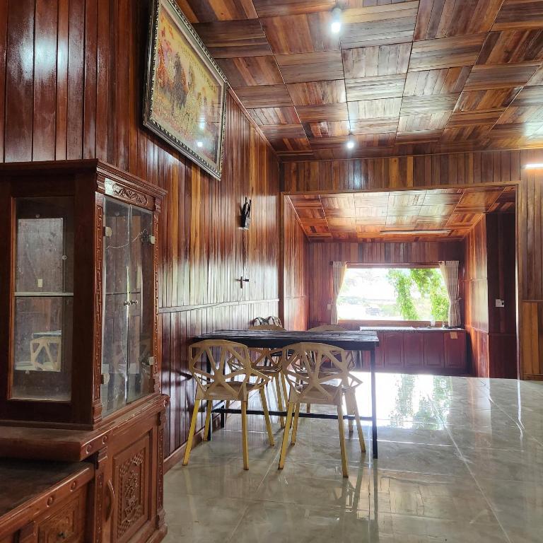 a dining room with wooden walls and a table and chairs at DalatXCamp Nystay in Ấp Kim Thạch