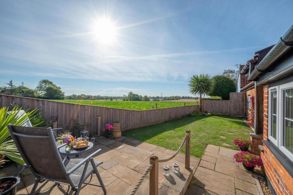 a patio with a table and chairs and a fence at 1 Bed in Saxtead oc-sfmhf in Saxtead