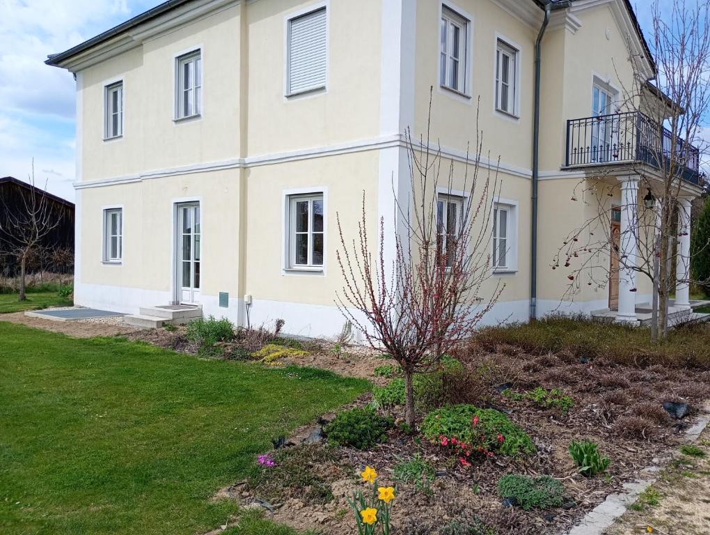 a large white house with a garden in front of it at Cottage Living in Leiblfing