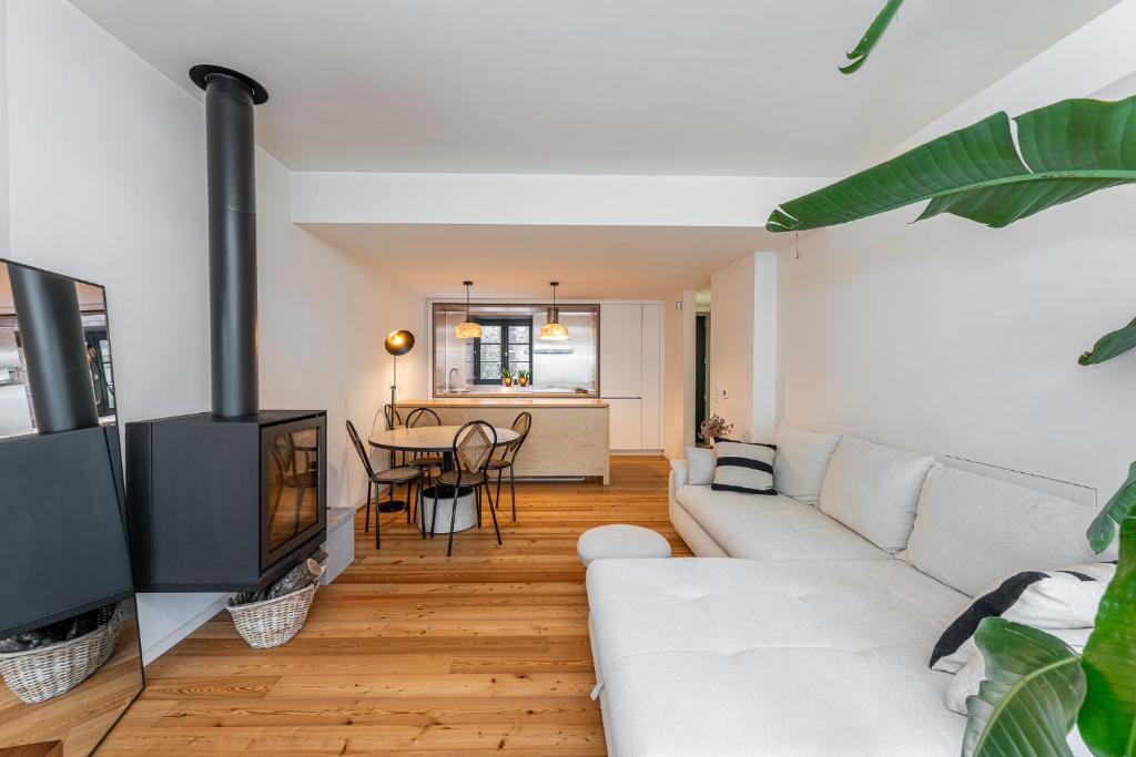 a living room with a white couch and a fireplace at Foz Velha River House in Porto