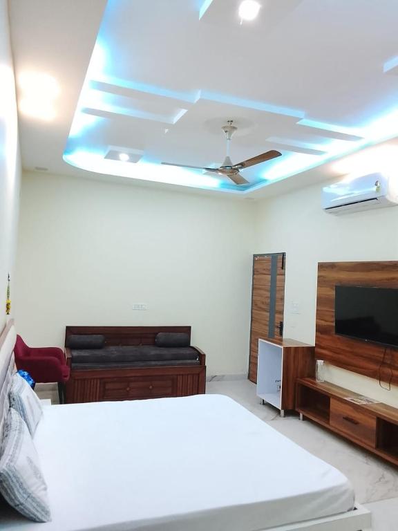 a bedroom with a ceiling fan and a tv at Hotel Amrindra in Kharar
