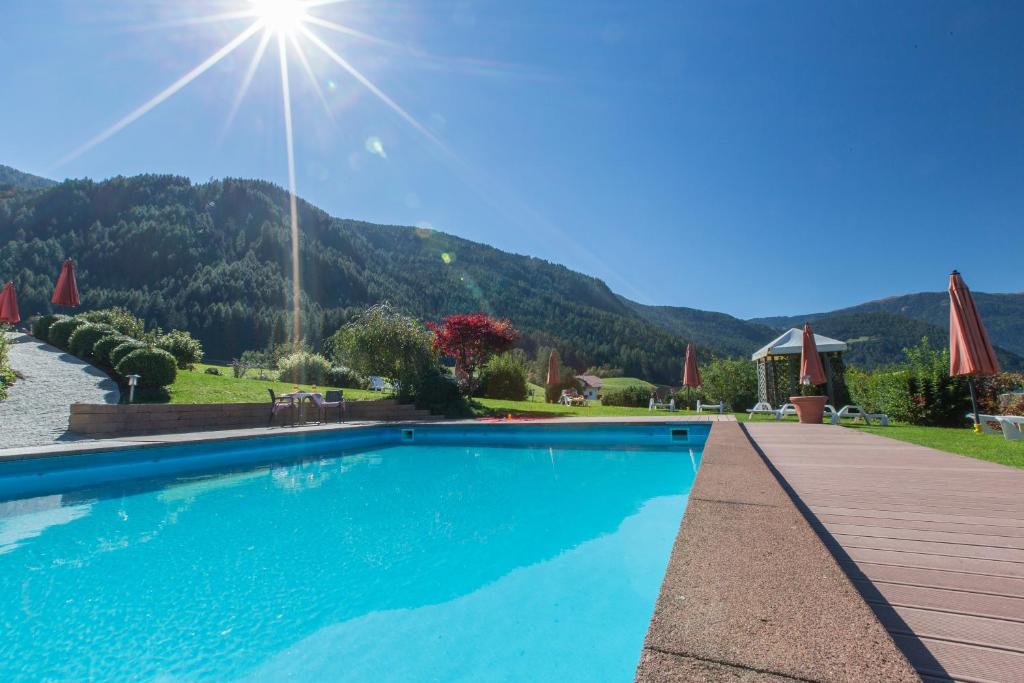 ein Schwimmbad mit einem Berg im Hintergrund in der Unterkunft Hotel Lindnerhof in St. Lorenzen