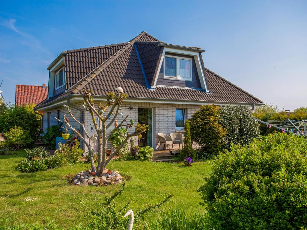 a house with a tree in the yard at Ferienwohnung Locke in Kluis