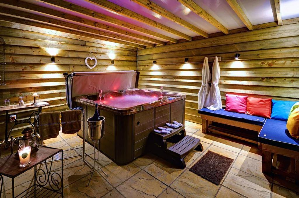 ein Zimmer mit Badewanne in einem Holzzimmer in der Unterkunft Alde Barn in Stonham Aspall