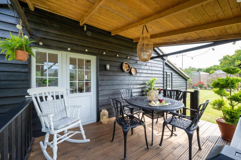 a patio with a table and chairs on a deck at 1 Bed in Trimley St. Martin nr Felixstowe oc-obat in Trimley Heath