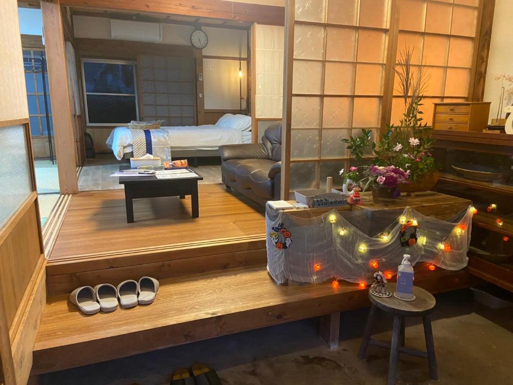 a living room with a couch and a table with shoes at おやど 瀬名 in Tanabe