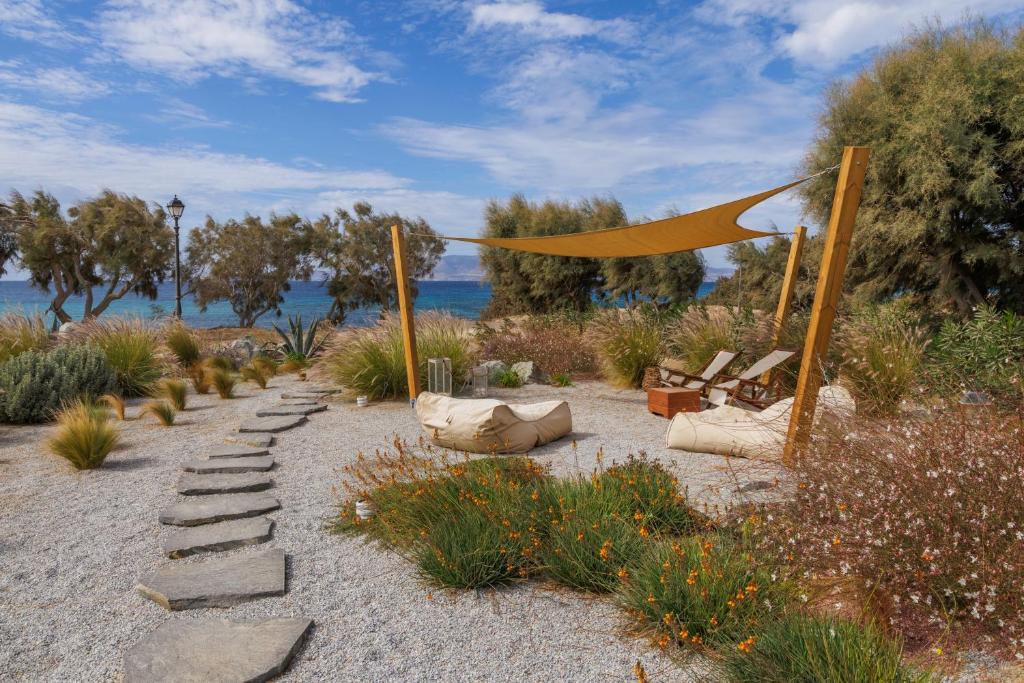a garden with a tent and some chairs and flowers at Thalassa Naxos in Kastraki