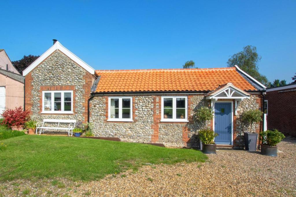 a brick house with a blue door and a yard at 2 Bed in Aldborough oc-2174 in Thurgarton