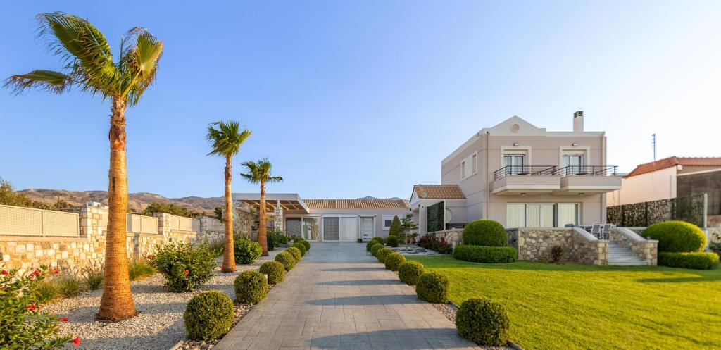 a house with palm trees and a walkway at Alkis Dream Villa with Jacuzzi in Kos