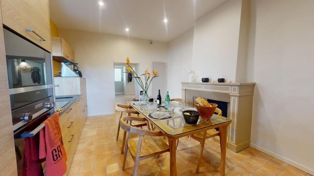a kitchen with a table with chairs and a stove at La tour de Grignan in Grignan