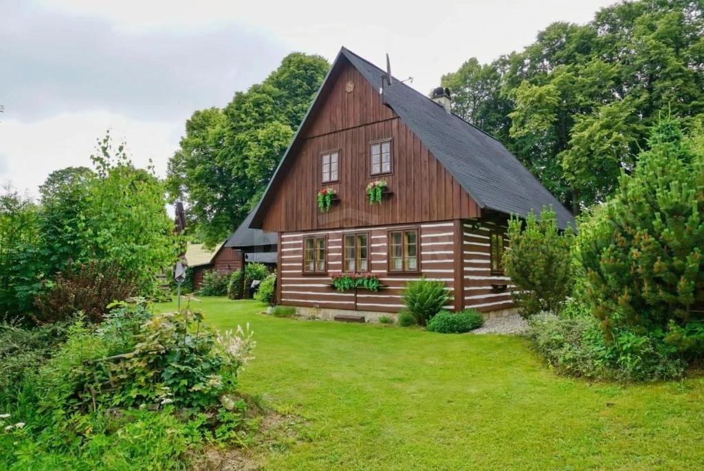 a large wooden barn with a black roof at Chalupa Dolní Hedeč blízko Dolní Moravy in Horní Orlice
