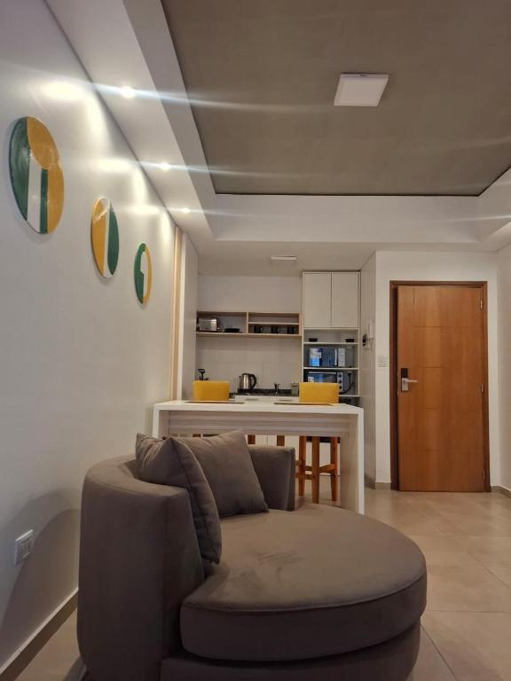 a living room with a couch and a kitchen at Toscana Apart in San Miguel de Tucumán