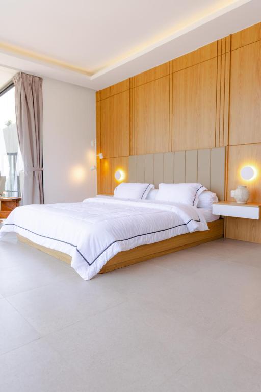 a bedroom with a large bed with a wooden wall at Manse 만세 Villa in Ciburial
