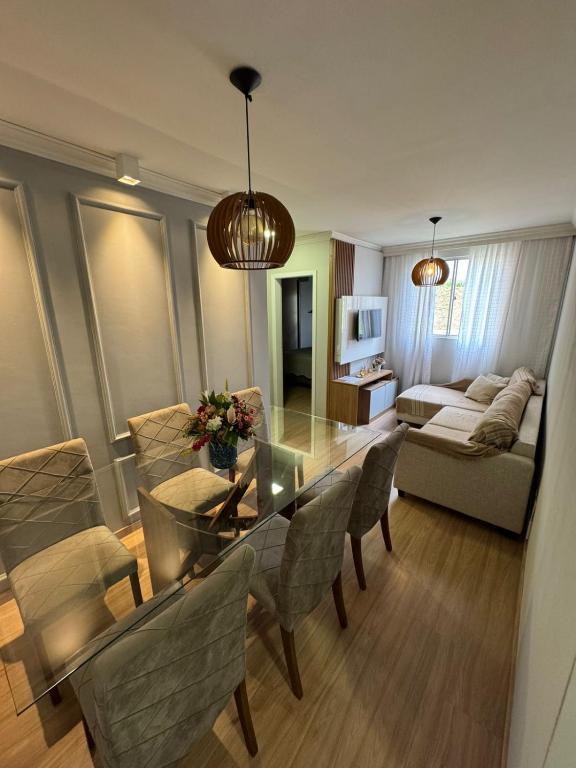 a living room with a glass table and chairs at Casa Matteucci 2 quartos in Londrina