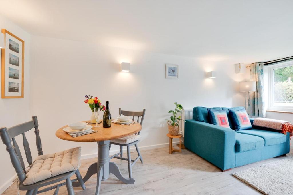a living room with a table and a blue couch at 1 Bed in Parracombe oc-smitho in Trentishoe