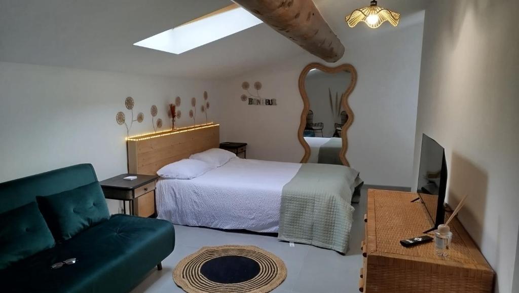 a bedroom with a bed and a couch and a table at le Cocon du Causse in Causse-de-la-Selle