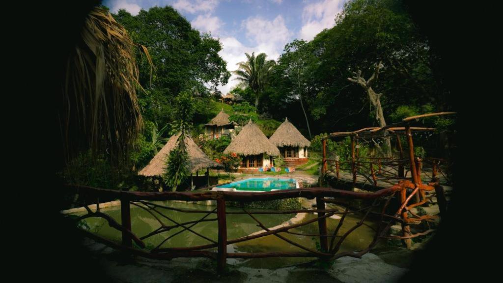 ein Resort mit Pool und einigen Hütten in der Unterkunft Tawaca SANCTUARY in Calabazo