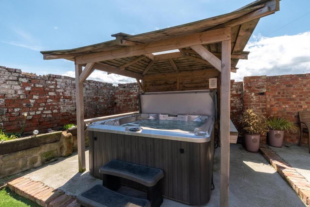 a hot tub under a wooden pergola at 2 Bed in Saltburn-by-the-sea oc-wa021 in Easington
