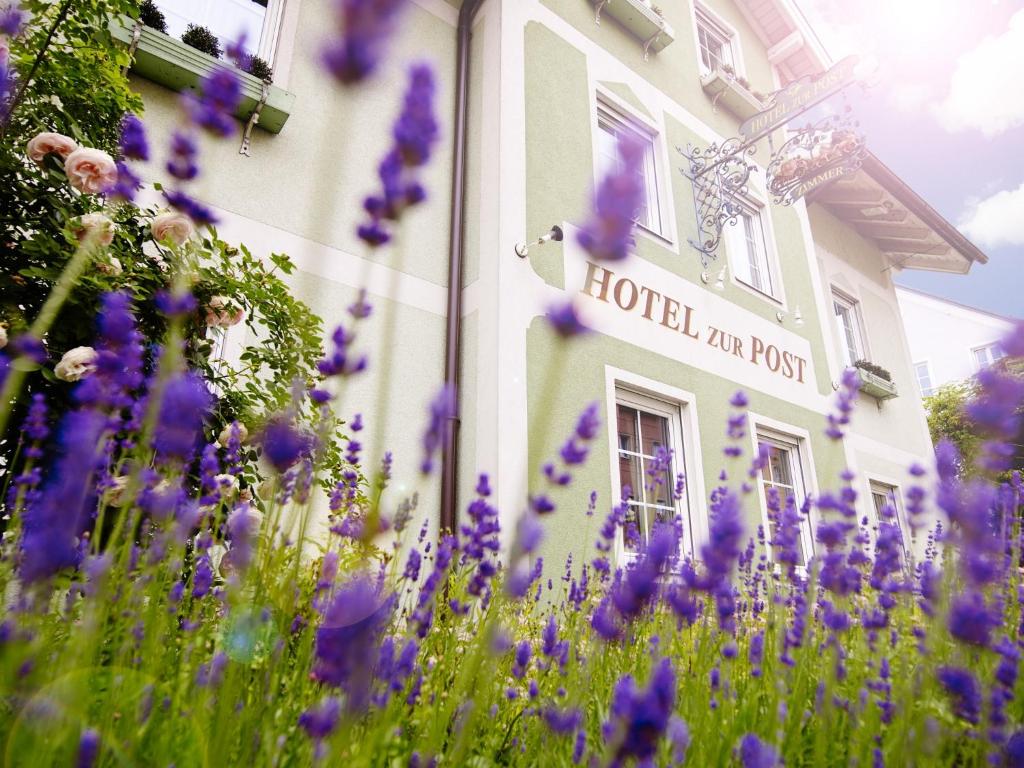 ein Gebäude mit lila Blumen davor in der Unterkunft Das Grüne Hotel zur Post - 100 % BIO in Salzburg