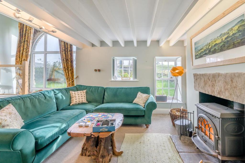 a living room with a green couch and a fireplace at 3 Bed in Askrigg oc-ds958 in Askrigg